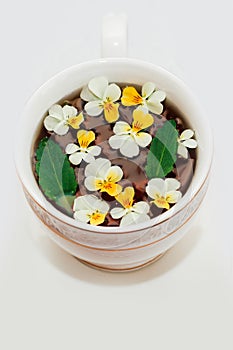 A beautiful white cup with a gold border decorated with flowers, herbal green healthy tea. Business account design.