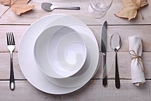 Beautiful white dishes, cutlery and napkin