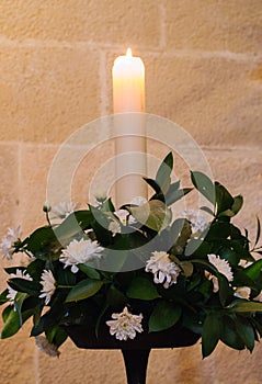 Beautiful white flowers with leaves and white glowing candle. Candle light with flowers. Romance background. Wedding decoration.