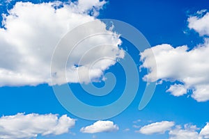 Beautiful white fluffy clouds slowly float against the blue sky on a warm sunny summer day