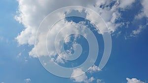 Beautiful white fluffy clouds slowly float against the blue sky on a warm sunny summer day. Timelapse video of cloud