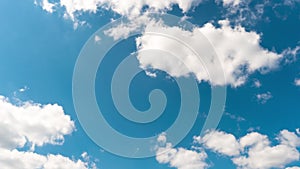 Beautiful white fluffy clouds slowly float against the blue sky on a warm sunny summer day. Timelapse video of cloud movement