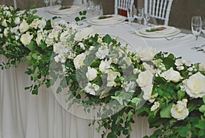 Beautiful White and Green Flower Decoration Arrangement on Wedding Table. Wedding Bridal Flower Decoration. photo