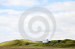 Beautiful white house against cloudy sky in Iceland.