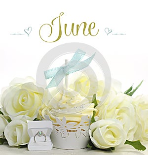 Beautiful white June Bride theme cupcake with seasonal flowers and decorations for the month of June