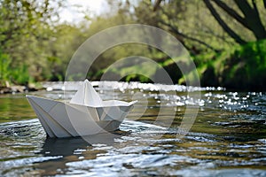 a beautiful white paper boat sailing along a spring stream in sunny weather,the concept of tourism,ecology,education,relaxation,