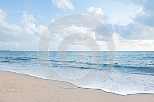 Beautiful white sand beach and ocean waves with clear blue sky photo