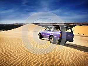 Beautiful white sand dunes with SUV car