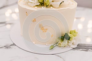 Beautiful white wedding or birthday cake with roses flowers on marble background. Festive event bakery
