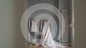 Beautiful white wedding dress hangs on a hanger on the mirror in the bedroom.