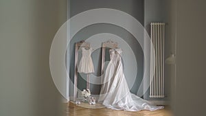 Beautiful white wedding dress hangs on a hanger on the mirror in the bedroom.