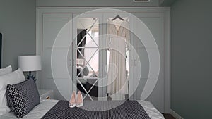 Beautiful white wedding dress hangs on a hanger on the wardrobe in the bedroom.