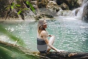 Beautiful white woman at a Erawan waterfall