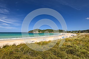 Beautiful wide angle view of Matapouri Beach near Whangarei on the North Island of New Zealand. Grass in the foreground