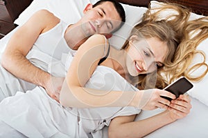 Beautiful Wife texting with lover on smartphone