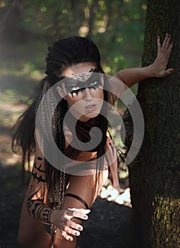Beautiful wild Amazon girl hunts in the forest. Shaman girl with long black hair, we follow the trail