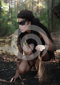 Beautiful wild Amazon girl hunts in the forest. Shaman girl with long black hair, we follow the trail