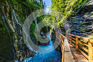 Beautiful Wimbachklamm gorge with wooden path in autumn colors, Ramsau bei Berchtesgaden in Germany. Waterfall at Wimbachklamm