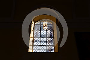 Beautiful window and a lamp in the german catholic church. Light and shadow