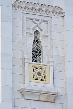 Beautiful window with an ornament on a white wall.