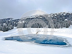 Beautiful winter atmosphere on storage lake Valos or reservoir lake Valos (Speichersee Valos) above the Lenzerheide