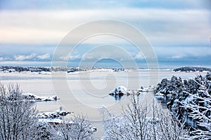 Beautiful winter day at Odderoya in Kristiansand, Norway. Trees covered in snow. The ocean and archipelago in the