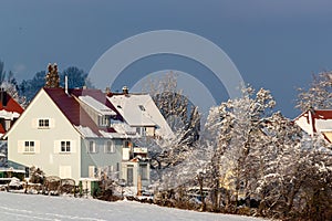 Beautiful winter in a European village - view of a snow-covered field against the backdrop of country houses