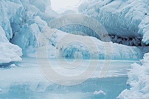 Beautiful winter landscape with blue ice cave grotto and frozen clear icicles. Lake Baikal, Russia. Great backdrop for