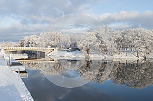 Beautiful winter landscape with bridge and nice reflection in water of river