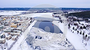 Beautiful winter landscape with buildings and a bridge over Ounasjoki River in Rovaniemi, Finland