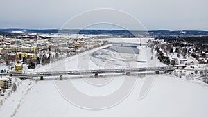 Beautiful winter landscape with buildings and a railway bridge over Ounasjoki River in Rovaniemi