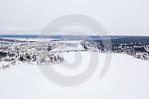 Beautiful winter landscape with buildings and a railway bridge over Ounasjoki River in Rovaniemi