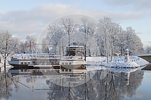 Beautiful winter landscape with cafeteria in shape of boat with nice reflection in water