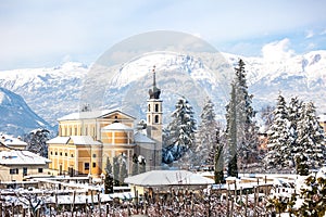 Beautiful winter landscape with church and Alps in Trento