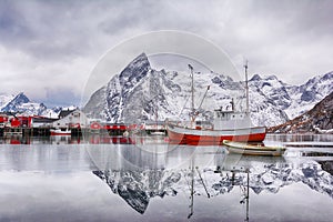 Beautiful winter landscape of harbor with fishing boat and traditional Norwegian rorbus