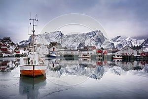 Beautiful winter landscape of harbor with fishing boat and traditional Norwegian rorbus