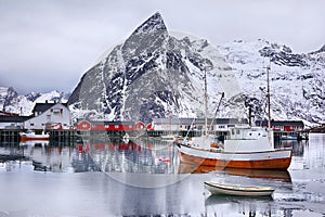 Beautiful winter landscape of harbor with fishing boat and traditional Norwegian rorbus