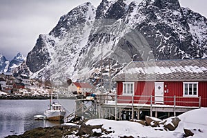 Beautiful winter landscape of harbor with fishing boat and traditional Norwegian rorbus