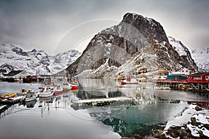 Beautiful winter landscape of harbor with fishing boats and traditional Norwegian rorbus