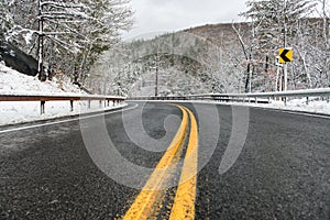 Beautiful winter landscape with highway road with turn and snow-covered trees.