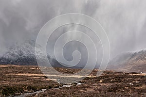 Beautiful Winter landscape image of Stob Dearg Buachaille Etive Mor viewed from Rannoch Moor with snowcapped peak with heavy snow