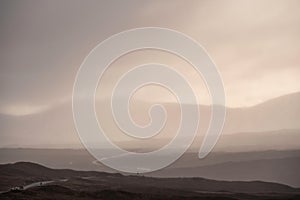 Beautiful Winter landscape image of view along Rannoch Moor during heavy rainfall giving misty look to the scene