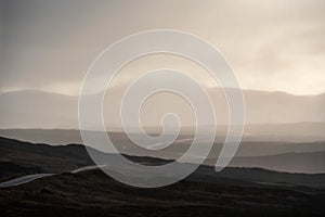 Beautiful Winter landscape image of view along Rannoch Moor during heavy rainfall giving misty look to the scene