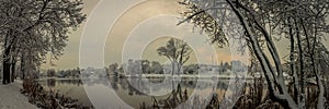 beautiful winter landscape. panoramic view from the river coast, lakes, pond in a snow-covered city park through coastal trees and