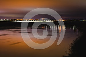 Beautiful winter night landscape with river and street lihgts