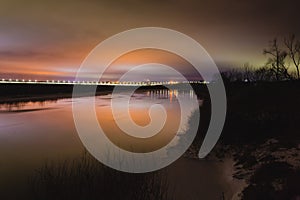 Beautiful winter night landscape with river and street lihgts