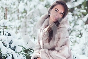 Beautiful winter portrait of young woman in park.
