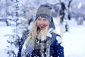 Beautiful winter portrait of young woman in the winter snowy scenery. Beautiful girl in winter clothes.