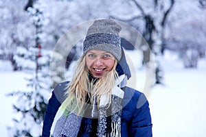 Beautiful winter portrait of young woman in the winter snowy scenery. Beautiful girl in winter clothes.