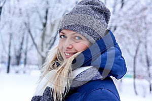 Beautiful winter portrait of young woman in the winter snowy scenery. Beautiful girl in winter clothes.